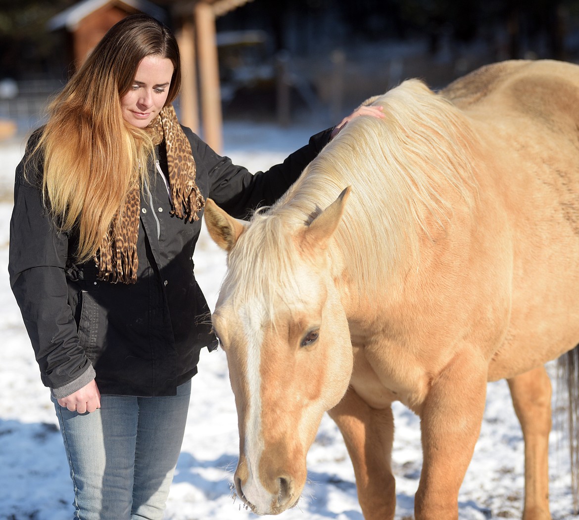 Kristina Gregersen with Corona, the son of Diva on Tuesday morning, October 29. Diva was Gregersen&#146;s 19 year old buckskin American Quarter Horse. Diva was killed by a shot from the highway on Saturday that seems to be malicious. Gregersen is hoping for information from anyone who may know something because she wants to protect the four remaining horses.
(Brenda Ahearn/Daily Inter Lake)