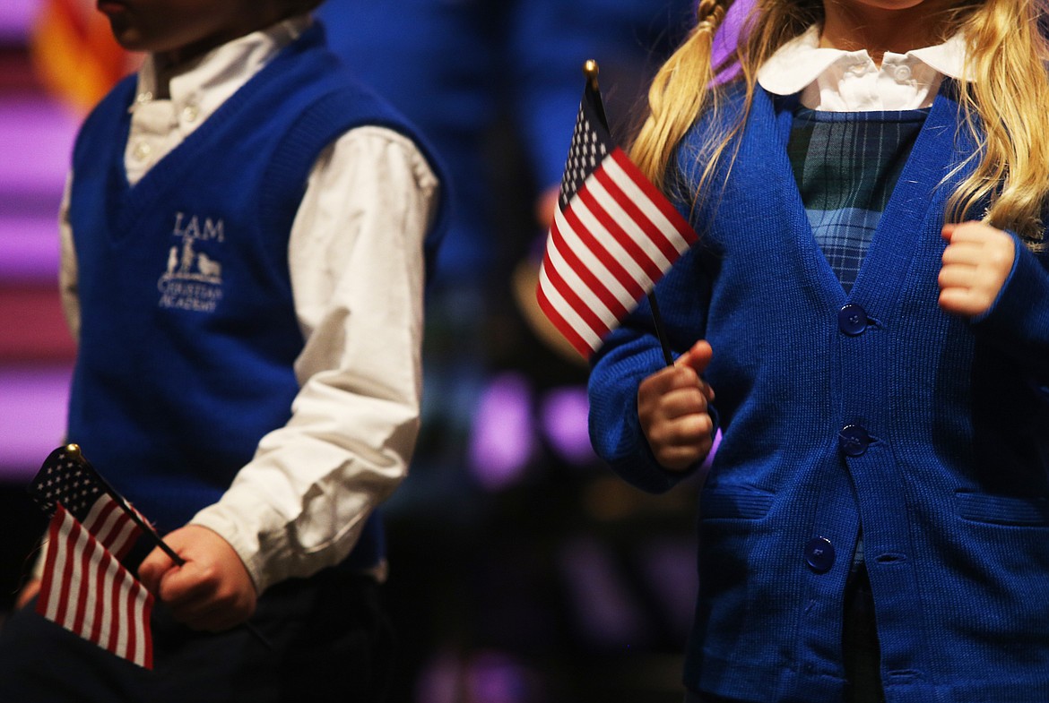 LAM Christian Academy students wave American flags during the school&#146;s Veterans Day performance Thursday at Coeur d&#146;Alene Bible Church.