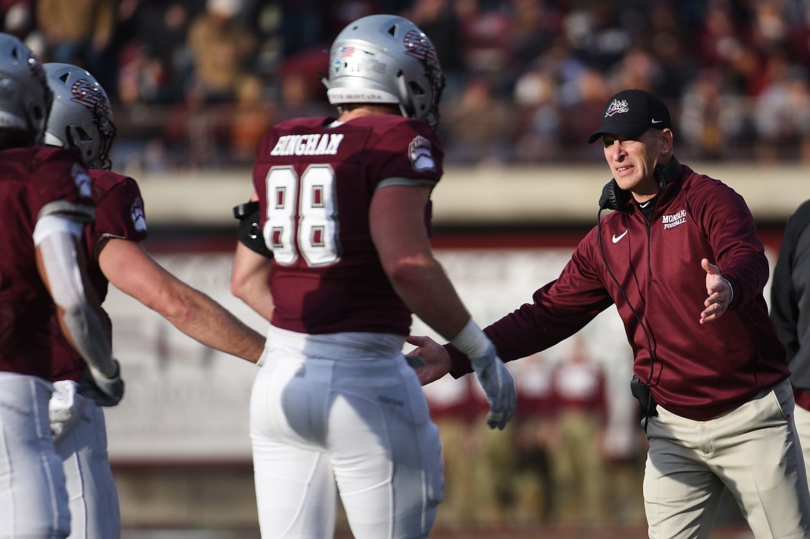 Montana head coach Bobby Hauck congratulates players after a second-quarter touchdown by running back Marcus Knight against Idaho at Washington-Grizzly Stadium on Saturday. (Casey Kreider/Daily Inter Lake)