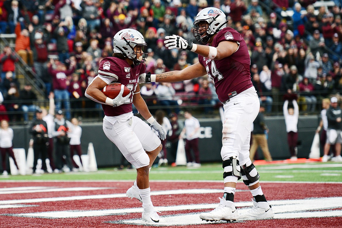 Montana Grizzlies running back Marcus Knight (21) celebrates with offensive tackle Dylan Cook (64) after a 2-yard, fourth-quarter touchdown run by Knight against the Idaho Vandals at Washington-Grizzly Stadium on Saturday. (Casey Kreider/Daily Inter Lake)