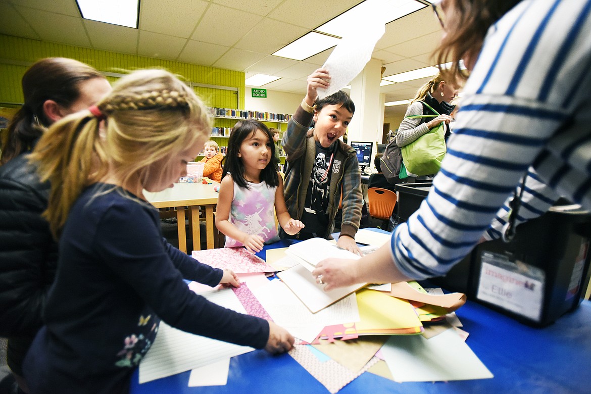 Emilio Gonzalez tears a piece of paper to begin making a collage-portrait of himself using torn paper at ImagineIF Library in Kalispell on Thursday, Nov. 7. (Casey Kreider/Daily Inter Lake)