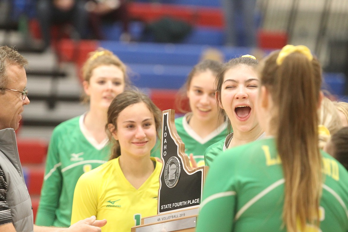 JASON ELLIOTT/Press
Lakeland High senior Jenny Wirtz celebrates after being presented the fourth-place trophy in the state 4A volleyball tournament by tournament director Mike Randles on Saturday at Coeur d&#146;Alene High.