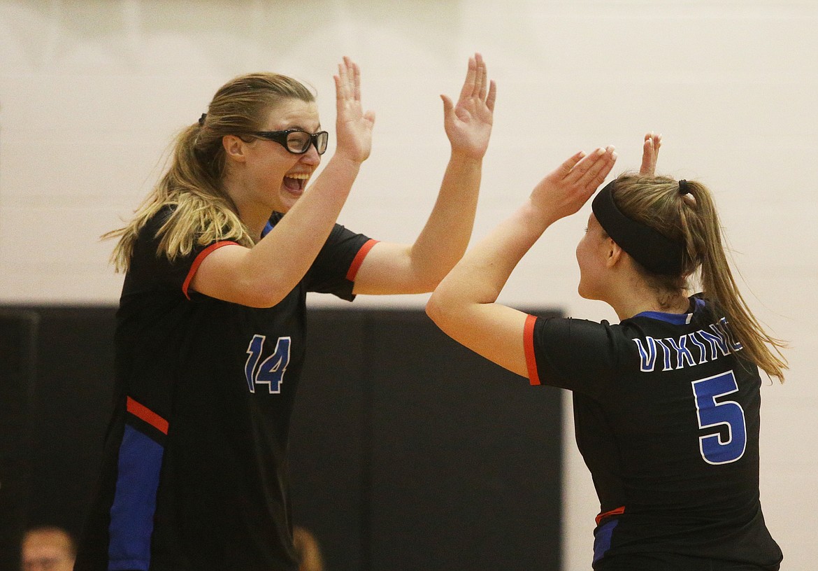 Coeur d'Alene's Elly Schraeder, left, and Sarah Wilkey celebrate a point in an Idaho State 5A volleyball tournament match against Timberline Friday at Post Falls High School. (LOREN BENOIT/Press)