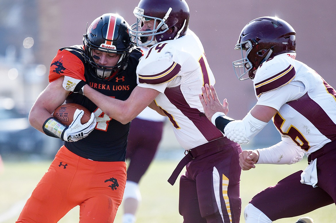 Eureka running back Chet McCully is forced out of bounds by Baker defenders Garrett Lesh (14) and Riley O'Donnell (16) on a run in the first quarter at Lincoln County High School in Eureka on Saturday. (Casey Kreider/Daily Inter Lake)