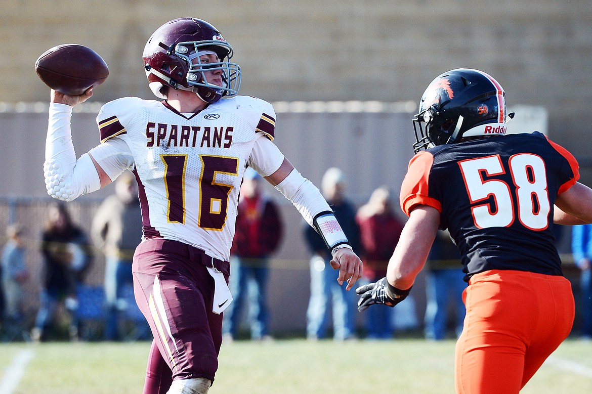 Baker quarterback Riley O'Donnell (16) looks to throw under pressure from Eureka defensive lineman Johnny Fehr (58) in the second quarter at Lincoln County High School in Eureka on Saturday. (Casey Kreider/Daily Inter Lake)