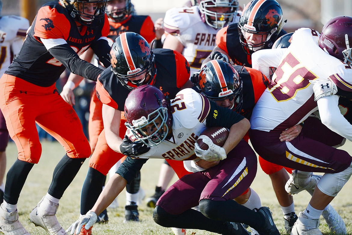 Baker running back Avery Uecker (20) is brought down by Eureka defenders in the second quarter at Lincoln County High School in Eureka on Saturday. (Casey Kreider/Daily Inter Lake)