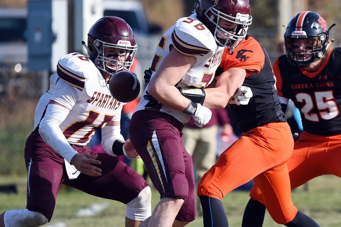 Eureka defensive lineman Johnny Fehr (58) recovers a fumble on the exchange between Baker quarterback Riley O'Donnell (16) and running back Dillon Hickey (36) in the first quarter at Lincoln County High School in Eureka on Saturday. (Casey Kreider/Daily Inter Lake)