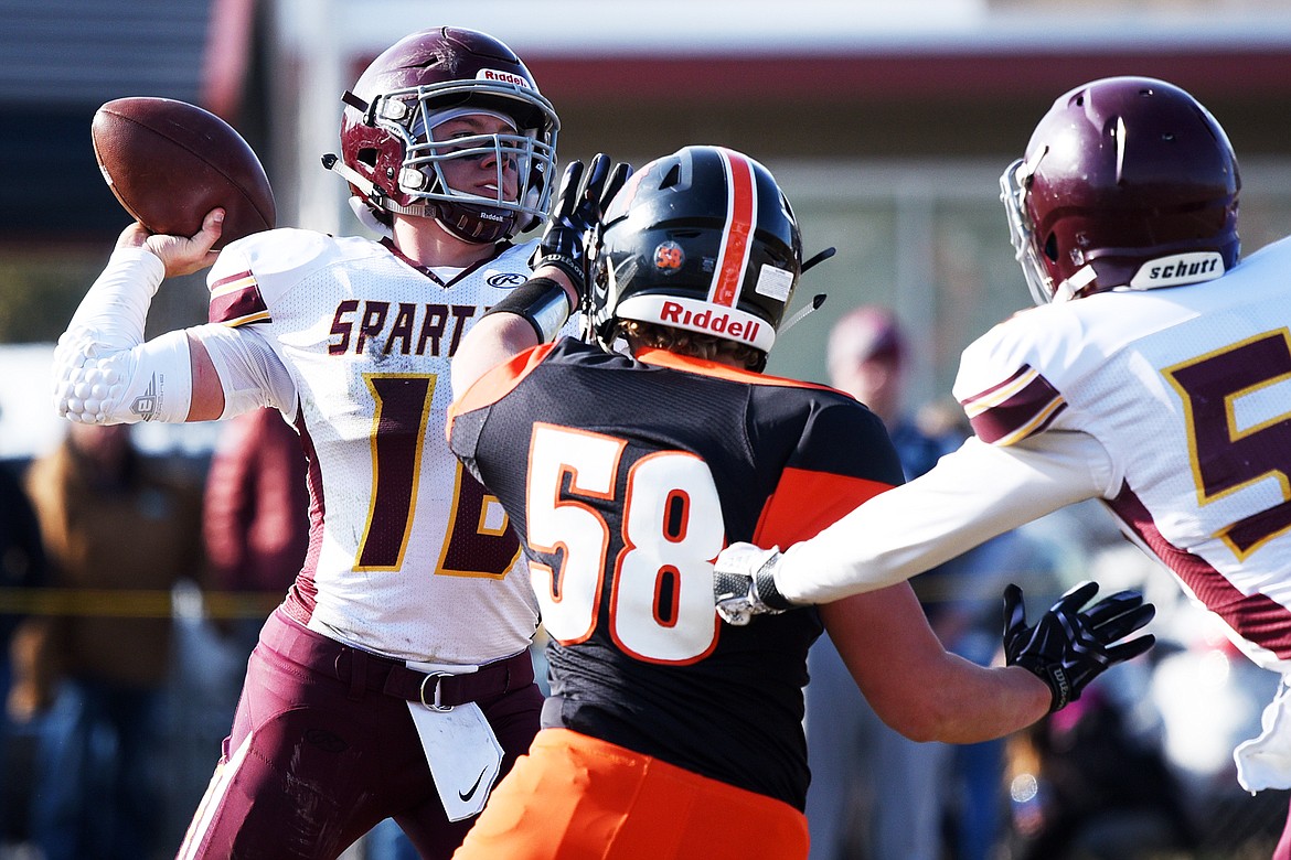 Baker quarterback Riley O'Donnell (16) looks to throw under pressure from Eureka defensive lineman Johnny Fehr (58) in the second quarter at Lincoln County High School in Eureka on Saturday. (Casey Kreider/Daily Inter Lake)