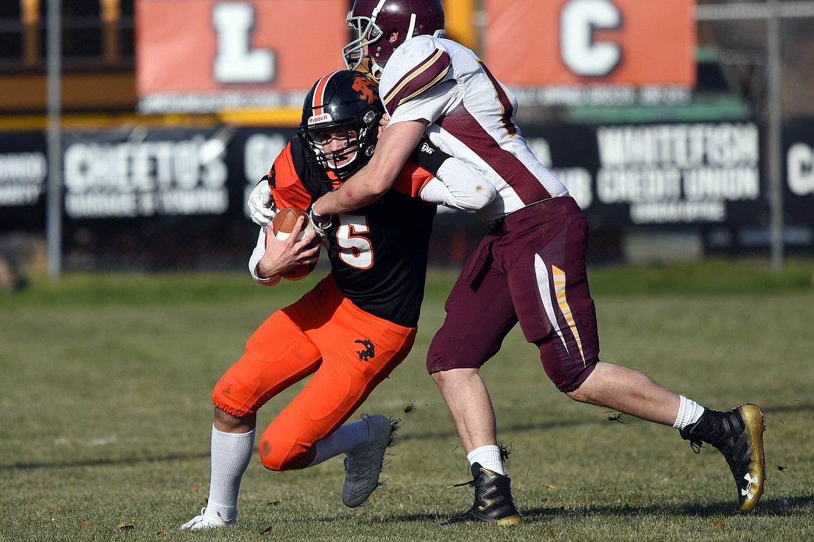 Eureka quarterback Hank Dunn (5) is brought down by Baker defender Garrett Lesh (14) on a second quarter run at Lincoln County High School in Eureka on Saturday. (Casey Kreider/Daily Inter Lake)