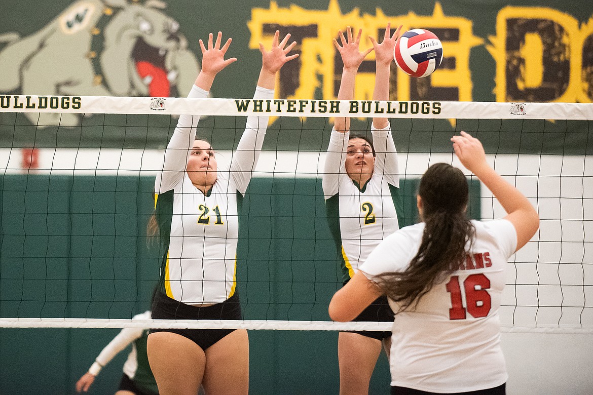 Hope Brown and Jadi Walburn rise for the block during Monday's play-in win over Browning. (Daniel McKay/Whitefish Pilot)