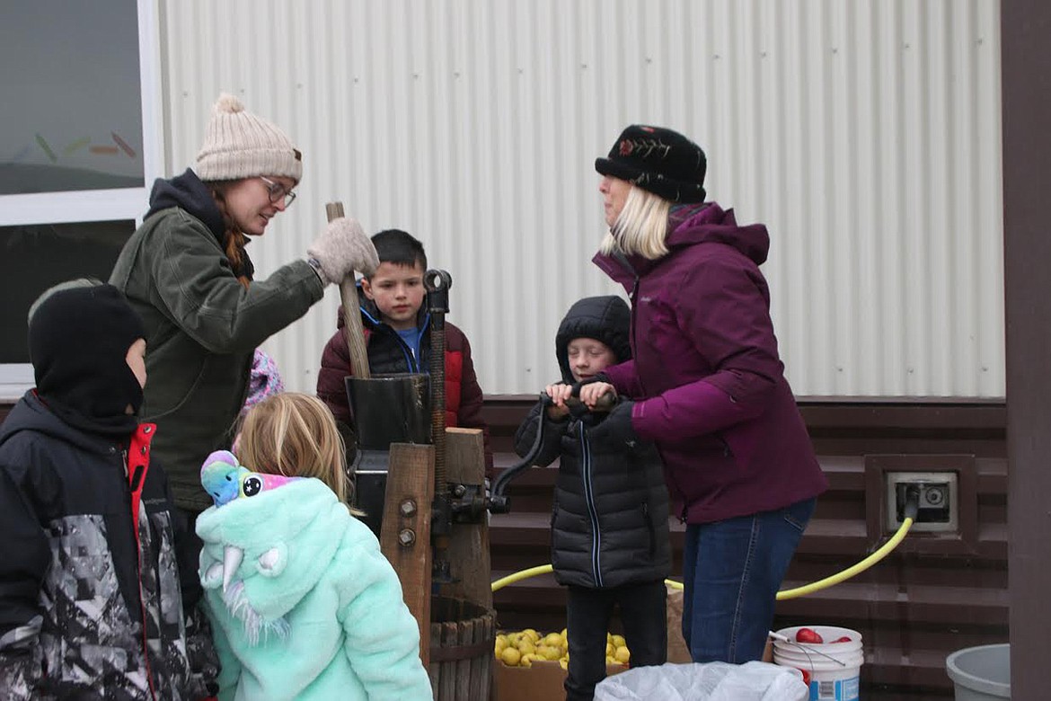 Mrs. Carpenter, Colt, Christian, Mrs. Browning, Kaia and Ben work the cider press at the Harvest Festival at Plains School on Halloween. (Lisa Larson/Valley Press)