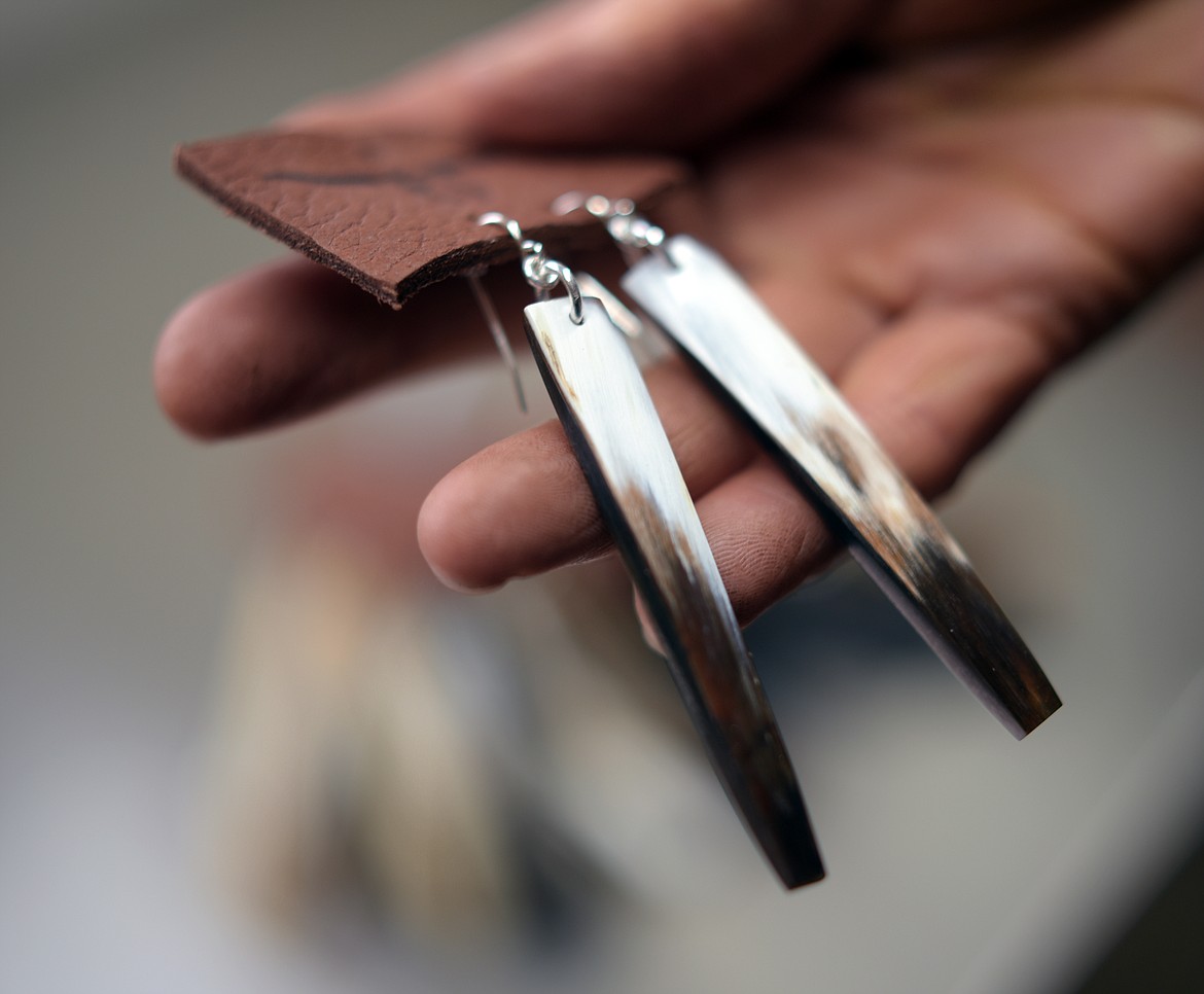 Sally Torres holds up a pair of earrings she made from horns in her studio on Monday, Oct. 21, in Columbia Falls. Torres will be taking part in the annual Majestic Valley Arena Holiday Extravaganza Nov. 8-10. (Brenda Ahearn/Daily Inter Lake)