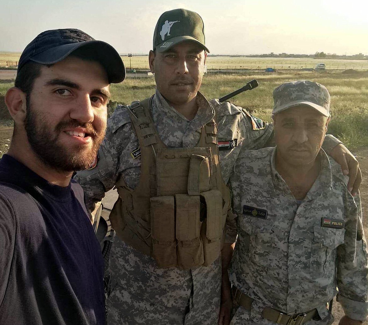 Saleh, who worked with an American relief organization during his country&#146;s war with ISIS, poses in Iraq with two Iraqi police trainees. (Courtesy photo)