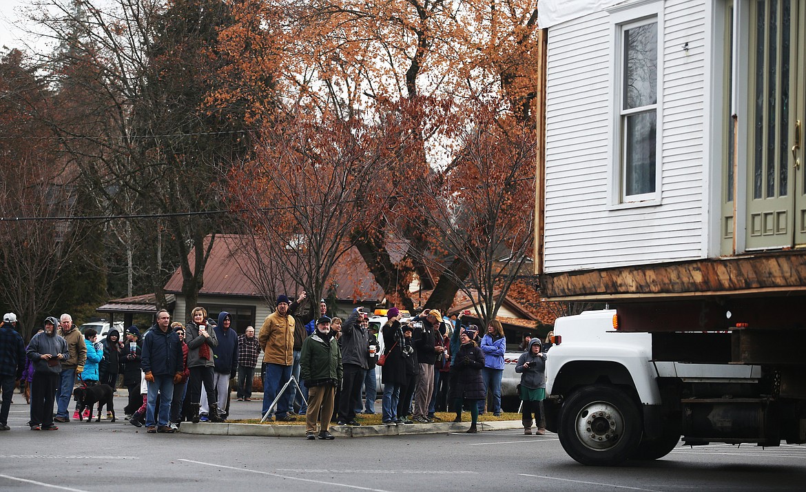 Spectators watch the historic J.C. White House move from its former location on Sherman Avenue to the base of Tubbs Hill on Saturday. (LOREN BENOIT/Press)