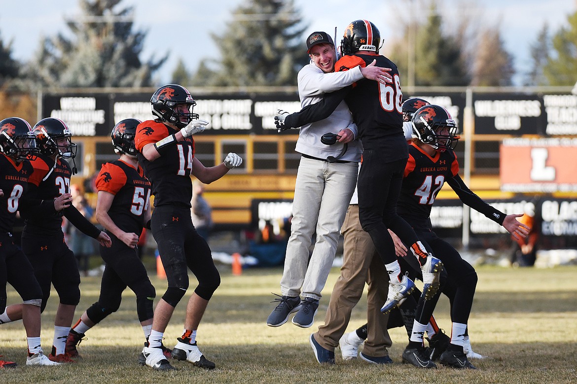 Eureka assistant coach Ryan Holder and linebacker Chance Muller (66) celebrate after a 39-35 win over Red Lodge in the State Class B semifinal at Lincoln County High School in Eureka on Saturday. (Casey Kreider/Daily Inter Lake)