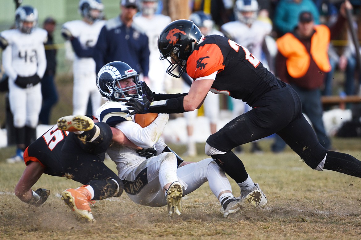 Eureka defenders Johnny Fehr (58) and Cory Chaney (25) sack Red Lodge quarterback Austin Heimer (2) in the third quarter in the State Class B semifinal at Lincoln County High School in Eureka on Saturday. Eureka won, 39-35. (Casey Kreider/Daily Inter Lake)