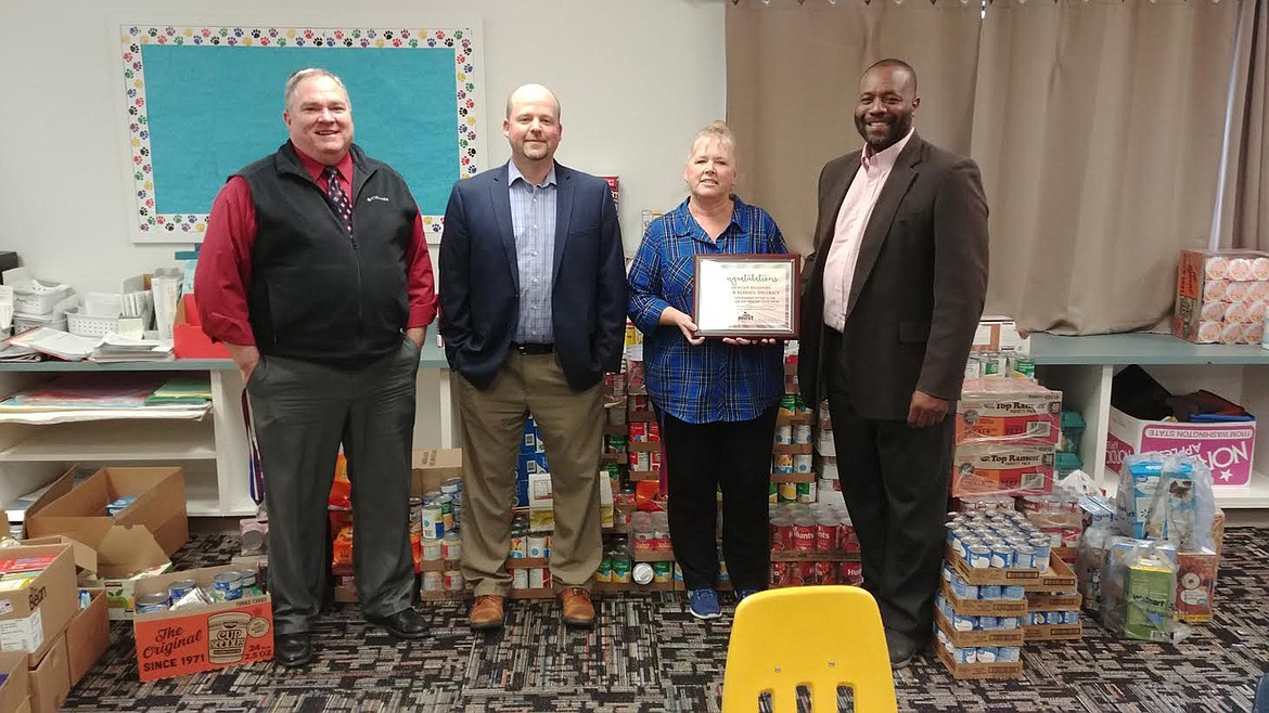 Superior Schools held a Halloween food drive and they tied with Havre and Drummond for most donations raised statewide. From left, are Scott Kinney, Superintendent of Superior Schools; Jeff Goody, marketing director for MUST; Dawn Bauer, Superior Elementary administrative assistant; and Andy Holmlund, CEO of MUST. (Chuck Bandel/Mineral Independent)