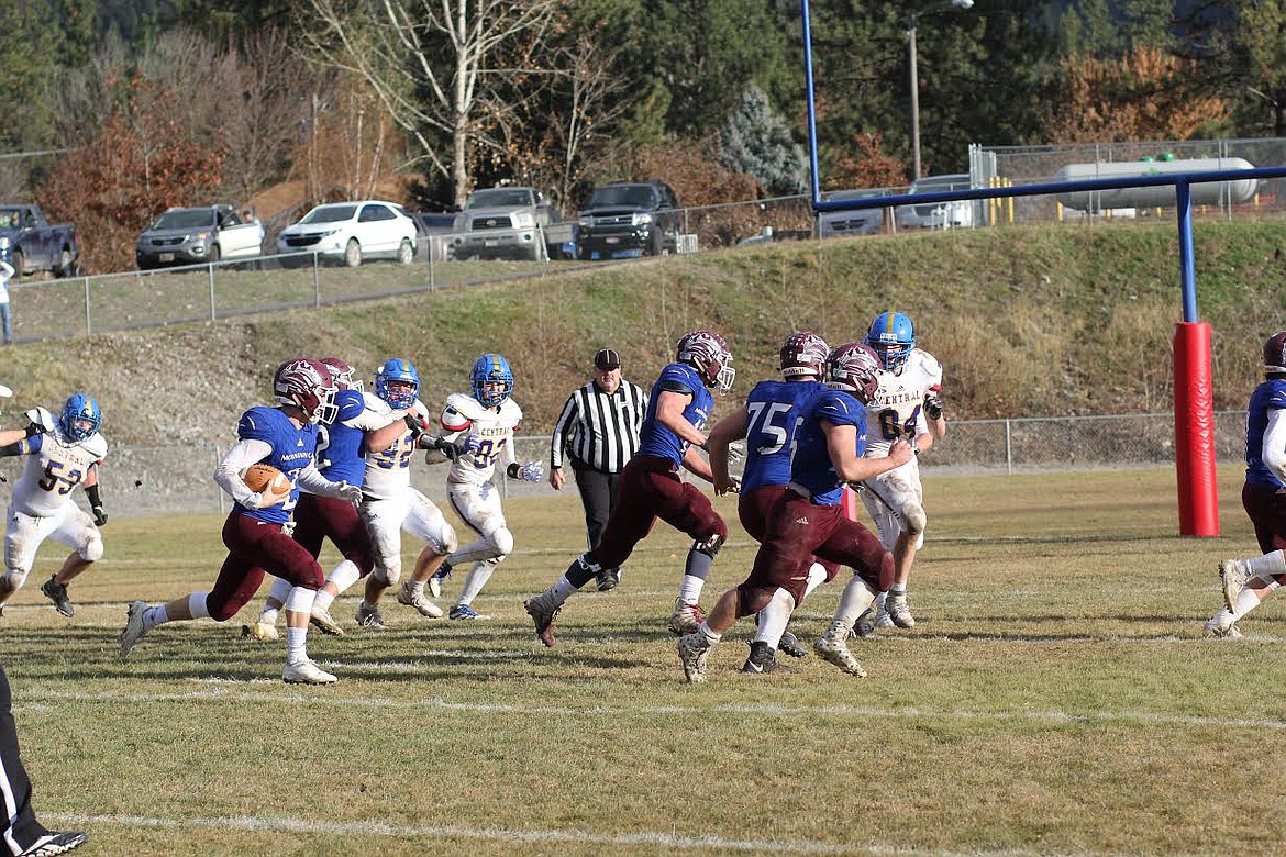 Clark Fork Mountain Cats quarterback Bryan Mask follows a wall of blockers led by Jacob Lipinski (75) on his way to a touchdown in the second half Saturday against Great Falls Central. Mask's running and throwing helped Clark Fork to a 44-14 win and a berth in the state title game. (Chuck Bandel/Mineral Independent)
