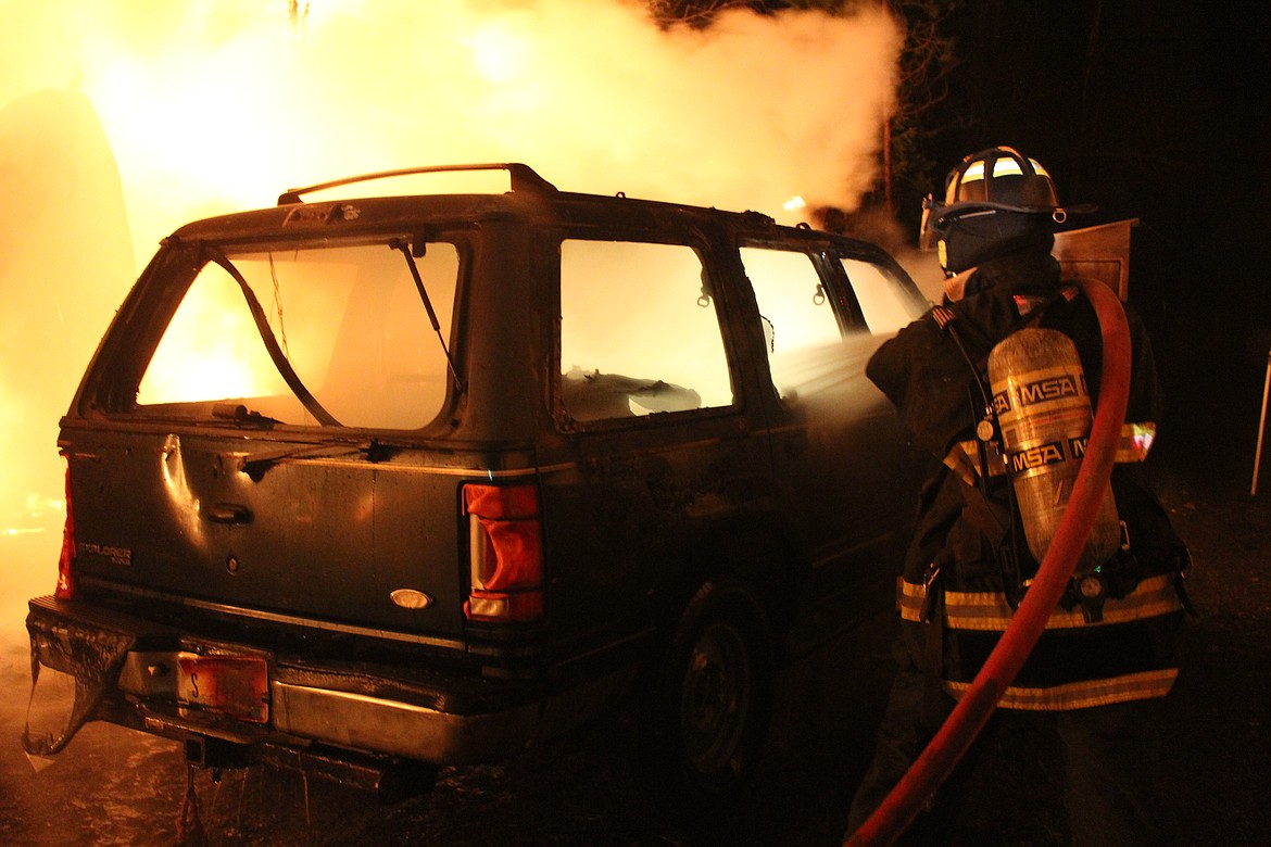 A SCFD No. 2 firefighter attempts to quell the fire that spread to one of the nearby vehicles.