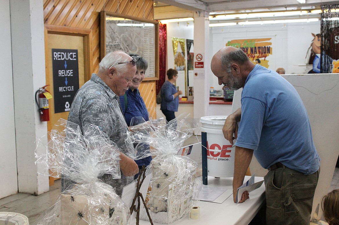 Rachal Pinkerton/Sun Tribune
Visitors to the Central Washington State Fair talk with Chester Ferguson (right) at the Central Washington Beekeepers Association display.