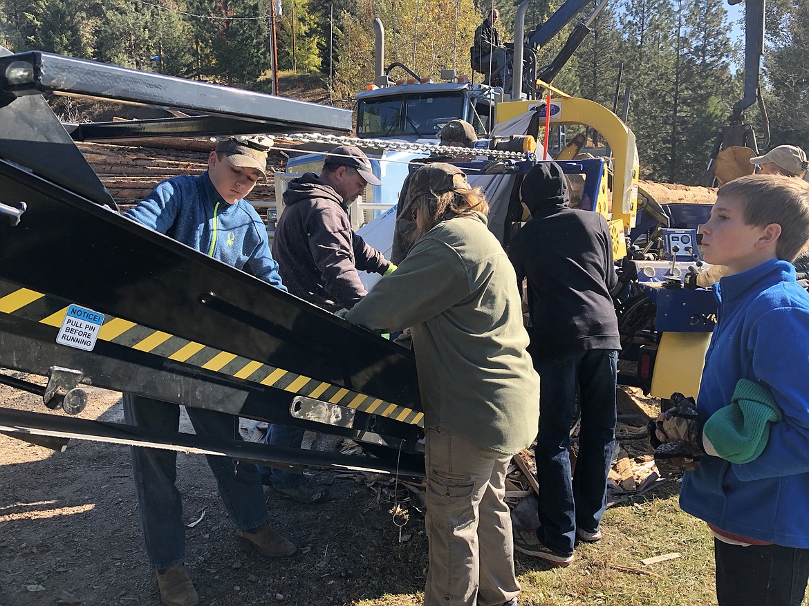 Volunteers line each side of the wood processor&#146;s conveyor. (Photo by Lance Jasper)