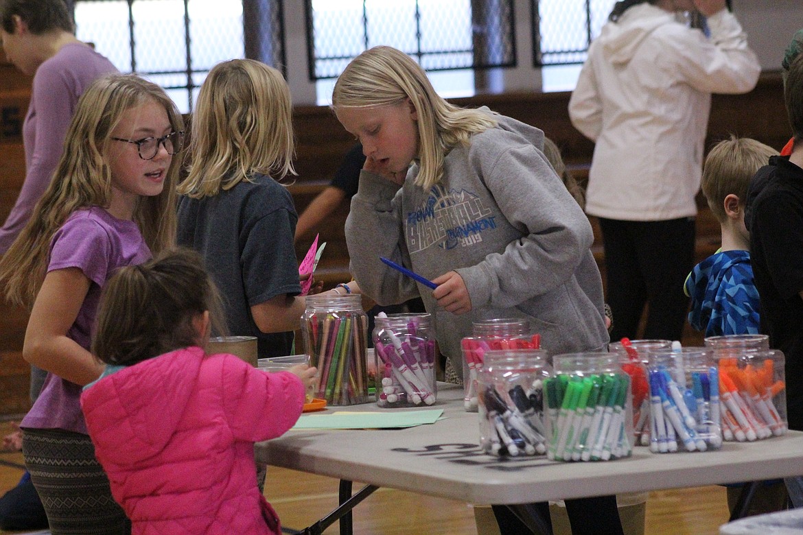 ADDY DEAL looks for colored markers while Lexi Franck and Sydney Lofthus put theirs away. (John Dowd/Clark Fork Valley Press)