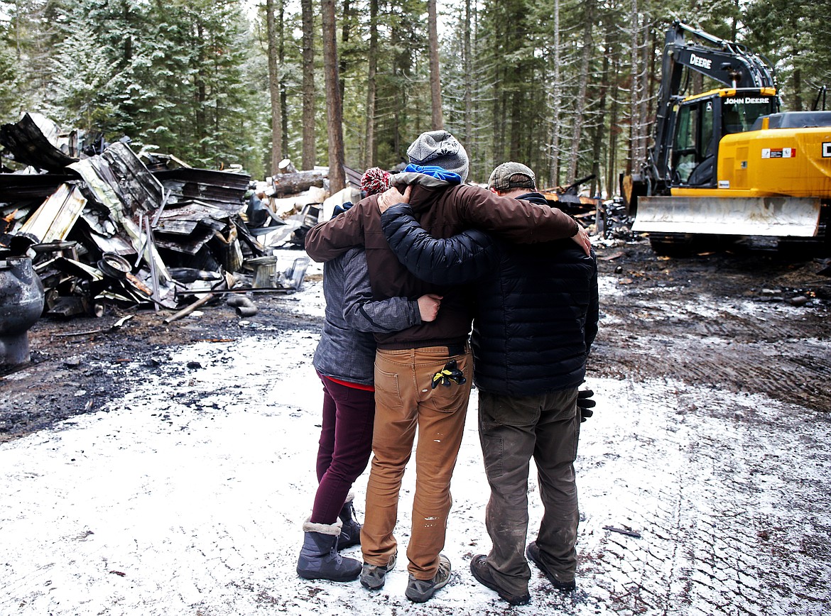 LOREN BENOIT/Press
Nina and Austin Brynjulvson pray for fellow artist Jeff May, right, in Athol. May lost his wood-carving shop to a fire on Jan. 21. Among the pieces lost was the Freedom Tree honoring veteran Fred McMurray that was at McEuen and his work that he had taken in to repair and maintain for the city. &#147;His ability to stay strong through this is amazing,&#148; said Austin.