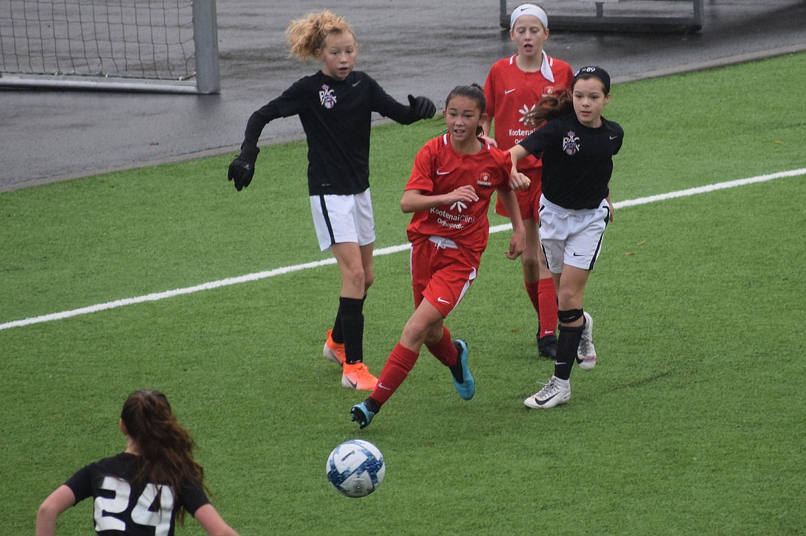 Photo by MARCEE HARTZELL
Thorns North FC 07 Girls Red mid-fielder Fiona Macdonald drives past three PAC NW Maroon defenders to score late in the second half, tying up the game 1-1 on Nov. 16 in Tukwila, Wash.  Ellie McGowan was in goal as the Thorns maintained first place in the league standings as they head into the latter half of the season.