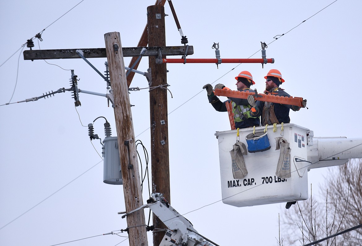Flathead Electric Cooperative workers repair a power pole and lines in this file photo. (Aaric Bryan/Daily Inter Lake FILE)