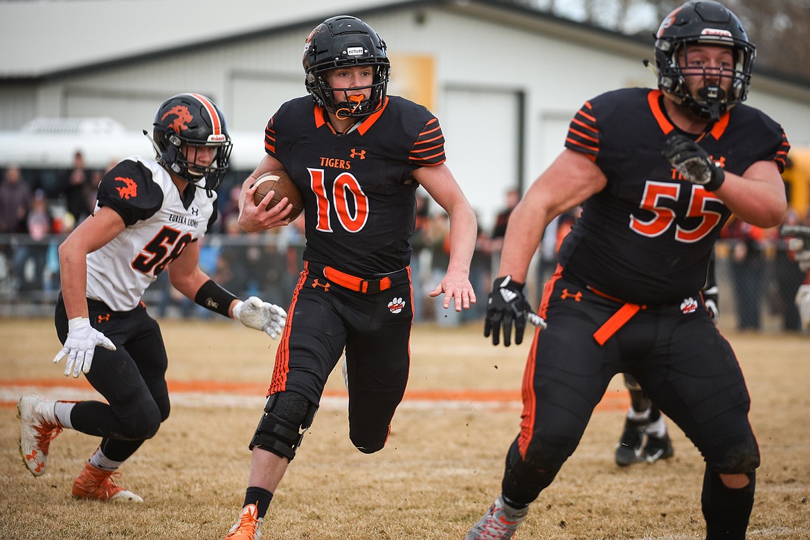 Manhattan quarterback Lane Veltkamp (10) looks for running room in the Class B State Championship against Eureka on Saturday. (Casey Kreider/Daily Inter Lake)