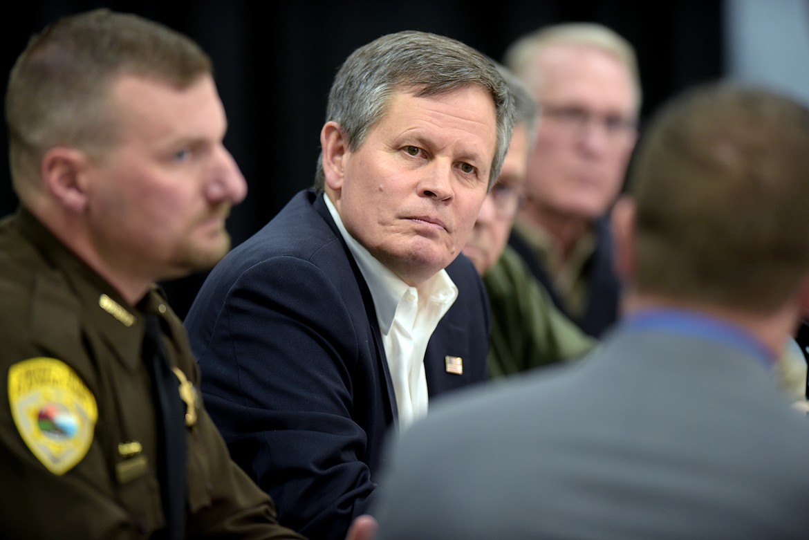 Senator Steve Daines listens intently as Commander of the Northwest Montana Drug Task Force Logan Shawback speaks about the how the meth crisis is impacting the Flathead Valley and beyond. Beside Daines is Flathead County Sheriff Brian Heino and in the far right background of the photo is Montana Attorney General Tim Fox.(Brenda Ahearn/Daily Inter Lake)