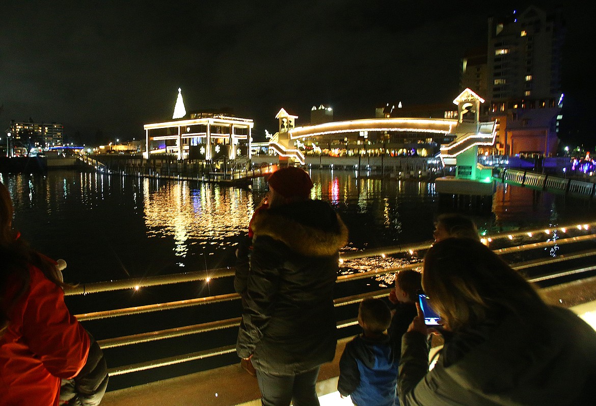 Guests look at Christmas light displays from the top deck of a Coeur d'Alene Resort cruise boat during a Journey to the North Pole Cruise on Tuesday. (LOREN BENOIT/Press)