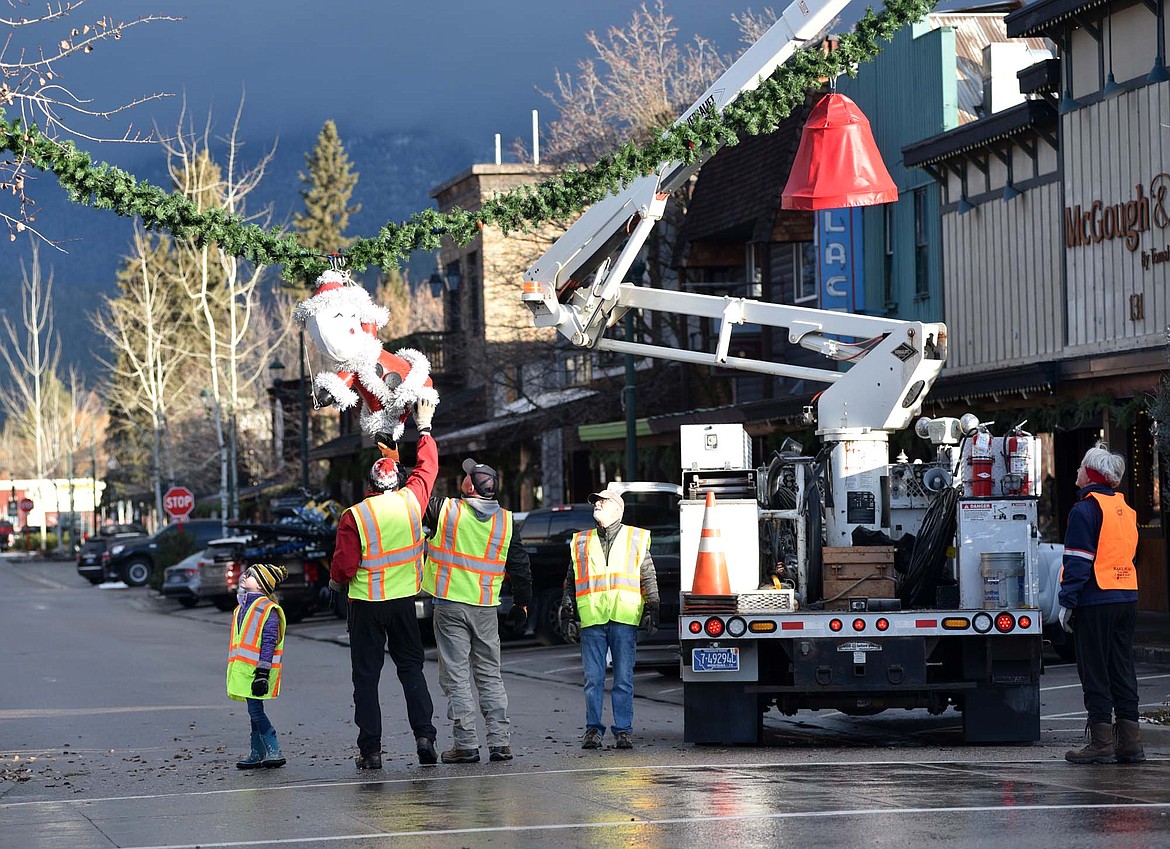 Volunteers hung the winter decorations downtown Sunday morning. (Heidi Desch/Whitefish Pilot)