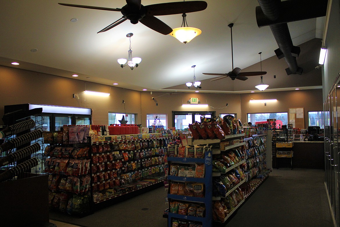 The stocked main area of the store is ready for customers with a variety of snacks, beer, soft drinks, among other convenience items. There is also a seating area.
