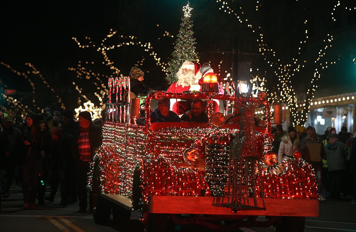 Santa waves to parade spectators from a decorated vintage fire truck. (LOREN BENOIT/Press)