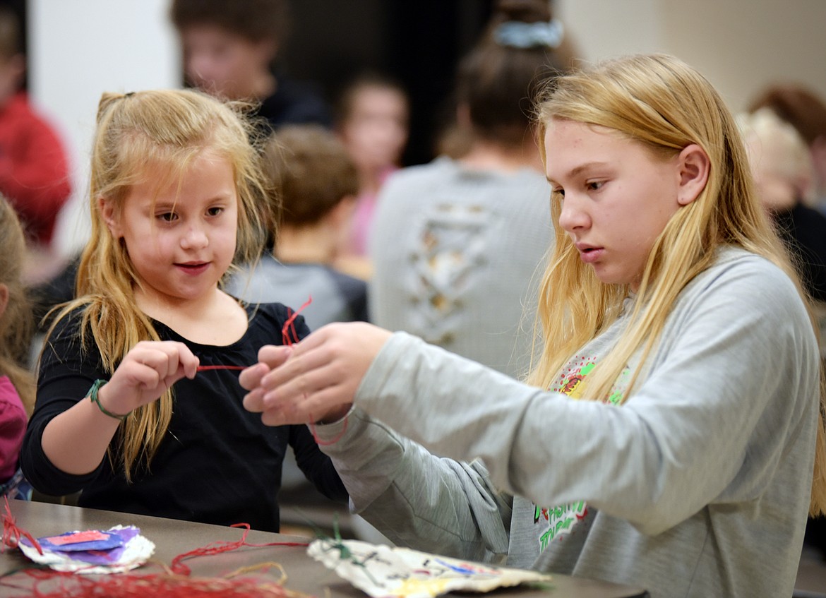 First-grader Malana Aneca, left, and seventh-grader Cazz Rankosky work together.