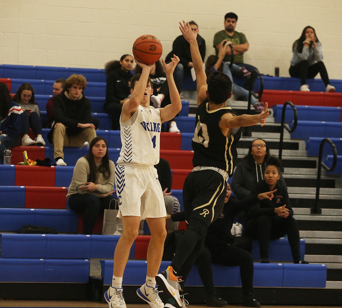 Coeur d&#146;Alene&#146;s Alex Karns shoots a 3-pointer over Rogers&#146; Robert Blocker on Friday night at Viking Court. (LOREN BENOIT/Press)