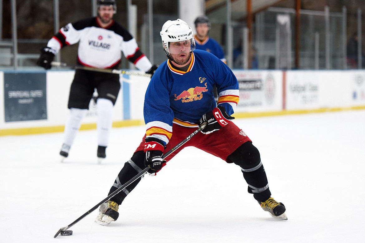 Kurt Barnett, of the Fun Beverage team from Kalispell, works the puck up the ice against Village Brewery during the Craft Brewers Cup at the Woodland Park Ice Center on Friday. The Craft Brewers Cup is the largest fundraiser of the year for the Flathead Valley Hockey Association. The tournament continues Saturday with games starting at 7 a.m. along with a brewfest from noon to 8 p.m. Seven local breweries will be in attendance Saturday with nearly 20 beers on tap.  (Casey Kreider/Daily Inter Lake)