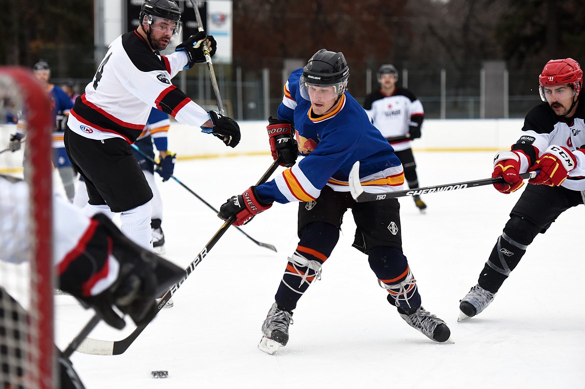 Jake Topp, of the Fun Beverage team from Kalispell, splits a pair of Village Brewery defenders and looks to shoot during the Craft Brewers Cup at the Woodland Park Ice Center on Friday. The Craft Brewers Cup is the largest fundraiser of the year for the Flathead Valley Hockey Association. The tournament continues Saturday with games starting at 7 a.m. along with a brewfest from noon to 8 p.m. Seven local breweries will be in attendance Saturday with nearly 20 beers on tap.  (Casey Kreider/Daily Inter Lake)