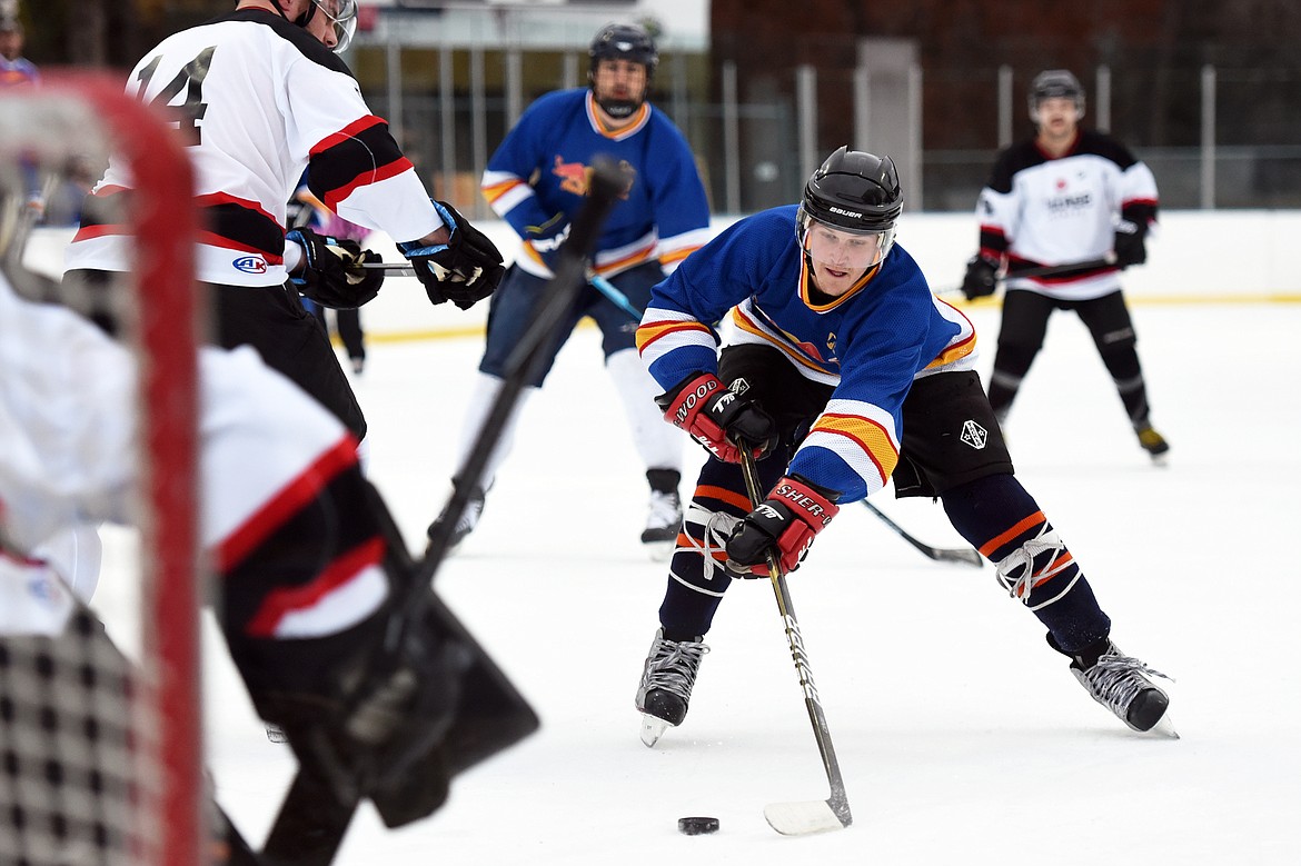 Jake Topp, of the Fun Beverage team from Kalispell, works the puck into the Village Brewery zone during the Craft Brewers Cup at the Woodland Park Ice Center on Friday. The Craft Brewers Cup is the largest fundraiser of the year for the Flathead Valley Hockey Association. The tournament continues Saturday with games starting at 7 a.m. along with a brewfest from noon to 8 p.m. Seven local breweries will be in attendance Saturday with nearly 20 beers on tap.  (Casey Kreider/Daily Inter Lake)