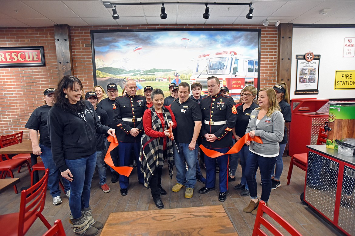 Toni Ann Kleinman cuts the ribbon at a ribbon-cutting ceremony at Firehouse Subs in Kalispell on Dec. 5.