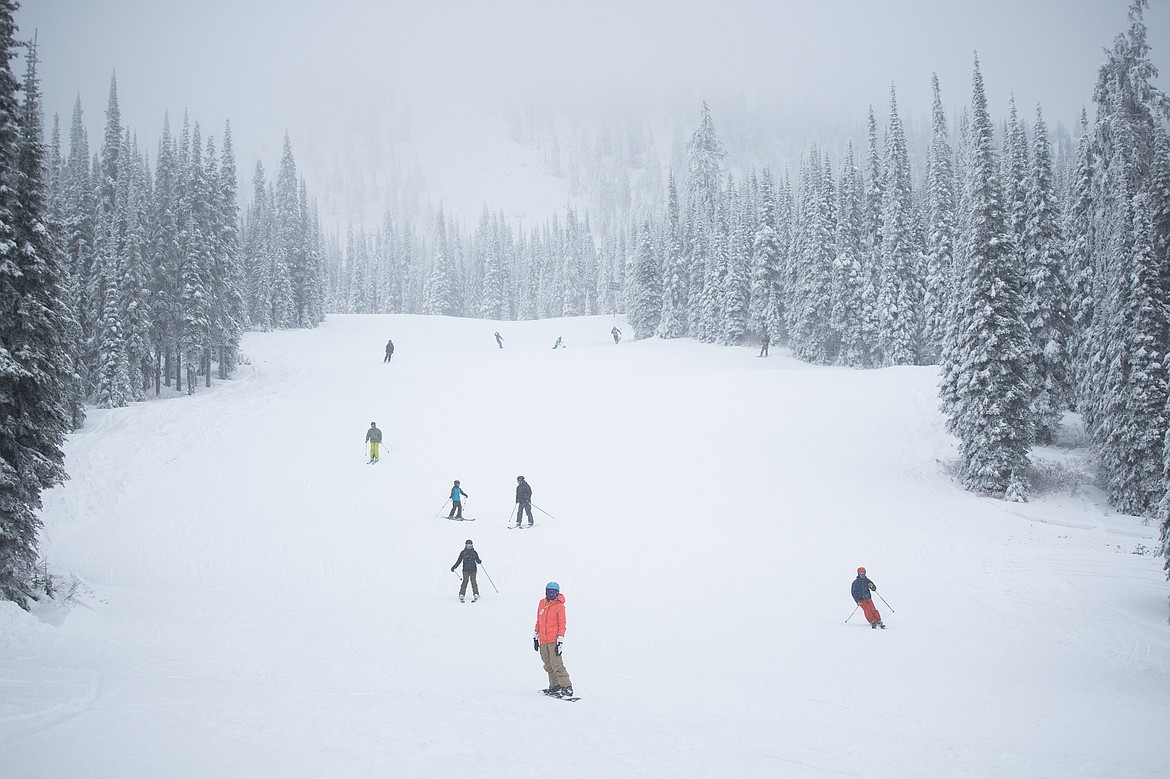 Top, skiers glide down Whitetail on the north side of Big Mountain on Friday for opening day at Whitefish Mountain Resort. Left, a snowboarder and a skier head up Chair 1 on opening day. The resort opened with limited terrain.  (Daniel McKay/Whitefish Pilot)