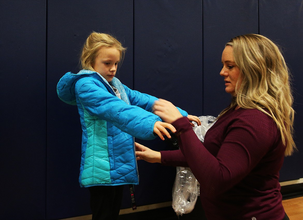 Lilian Shoemaker, 7, gets help from Boys and Girls Club employee Nicole Hammons, as she tries on a coat Friday at The Coeur d'Alene club. (LOREN BENOIT/Press)