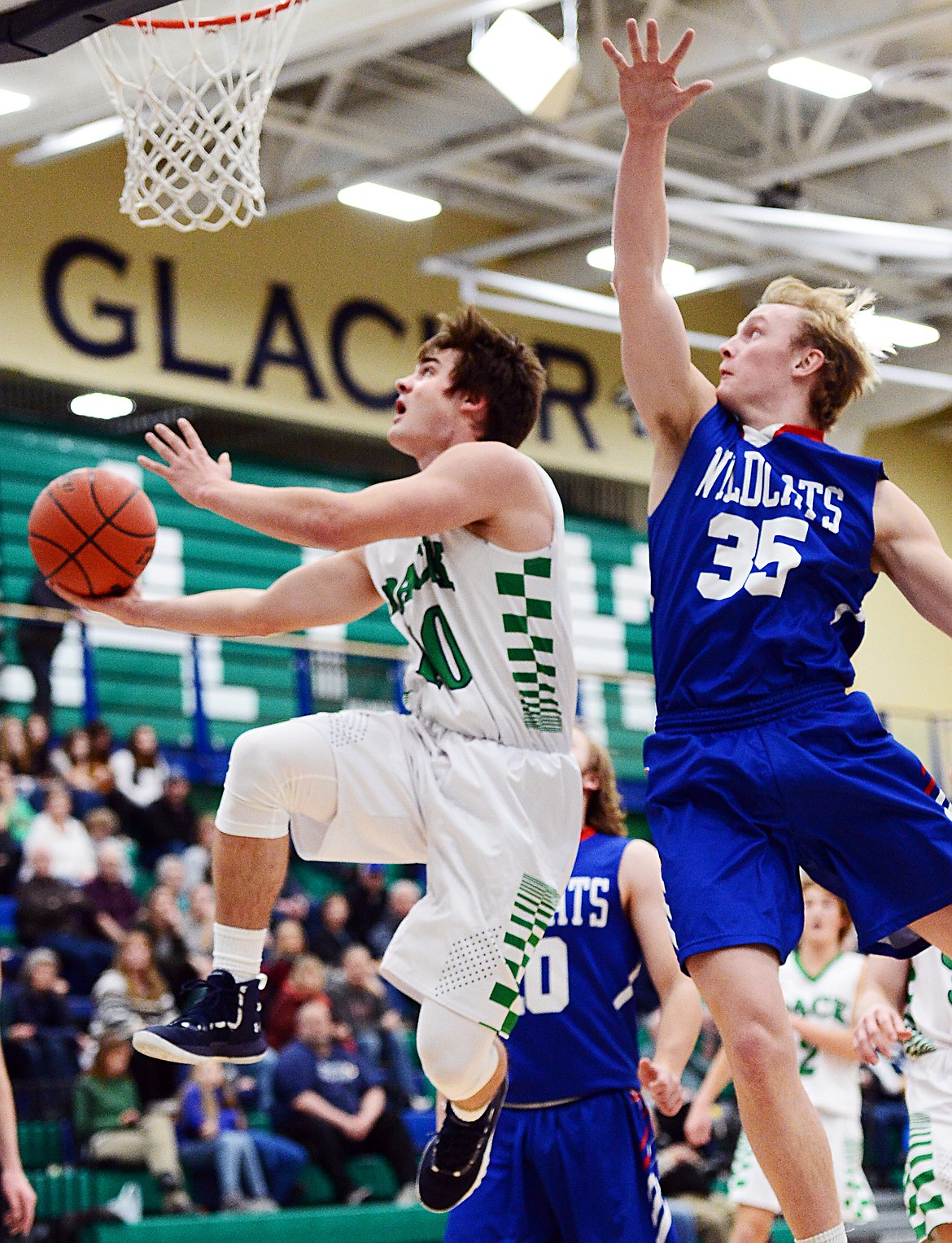 Glacier's KJ Johnson drives to the hoop for a reverse layup past Columbia Falls' Allec Knapton in the first quarter at Glacier High School on Thursday. (Casey Kreider/Daily Inter Lake)