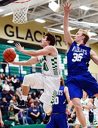 Glacier's KJ Johnson drives to the hoop for a reverse layup past Columbia Falls' Allec Knapton in the first quarter at Glacier High School on Thursday. (Casey Kreider/Daily Inter Lake)