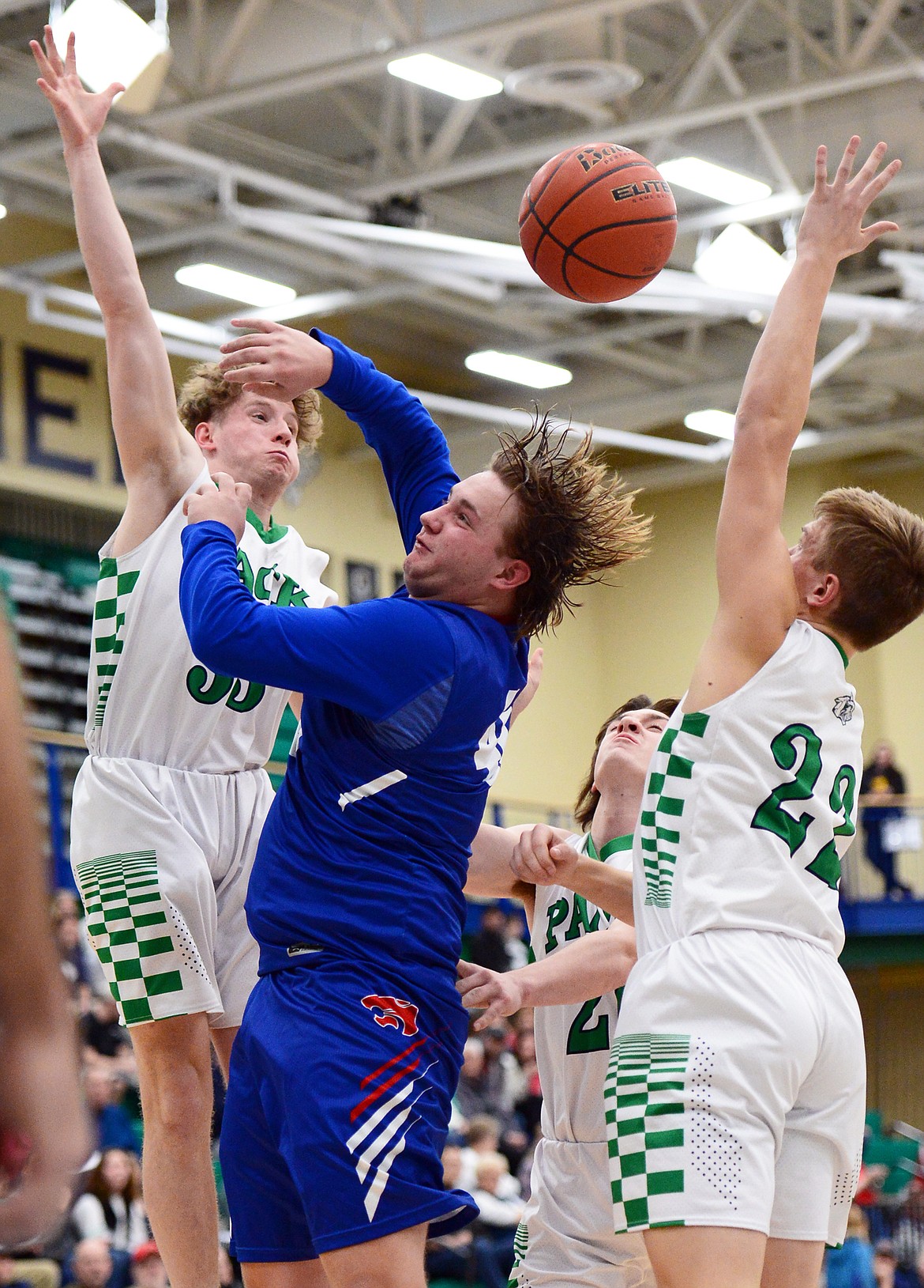 Columbia Falls' Jake Bulawsky battles for a rebound against Glacier's Colin Presnell, left, and Michael Schwarz at Glacier High School on Thursday. (Casey Kreider/Daily Inter Lake)