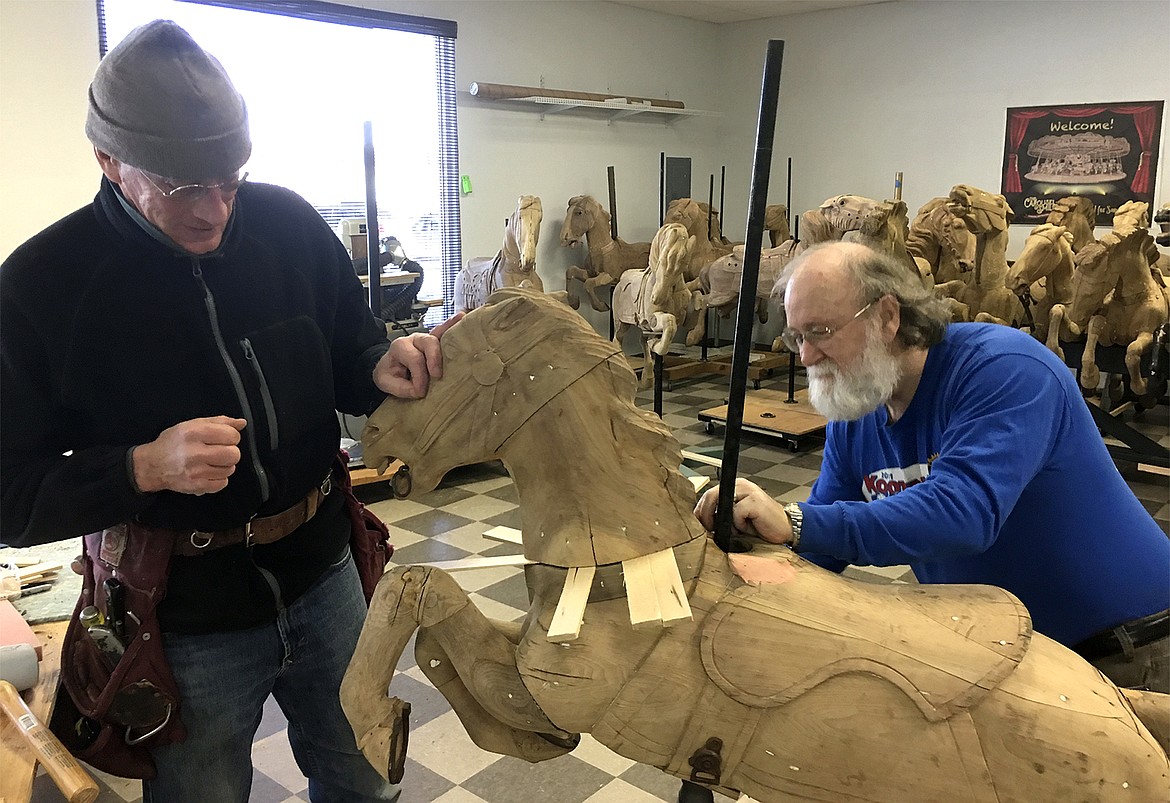 (Photo courtesy CLAY HUTCHISON)
Carousel of Smiles volunteers and members of what is known as the Godfather Squad, Dan Schwerin and Don Lang, prepare to remove a head from one of the ponies as part of the restoration process.