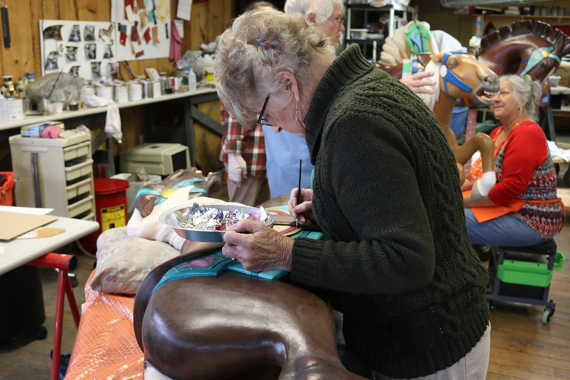 (Photo by MARY MALONE)
Carousel of Smiles volunteer Denys Knight puts some finishing touches on one of the ponies during a workshop in mid-November.