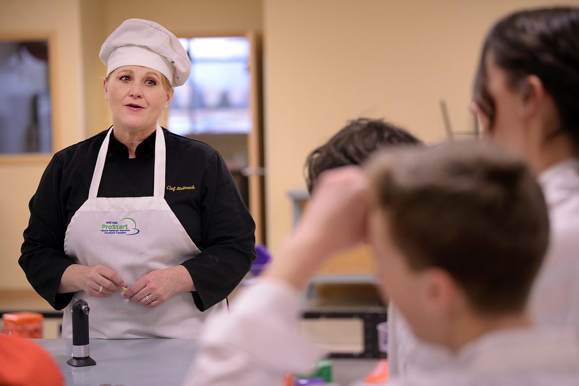 Tamara Fisher, culinary arts teacher at Glacier High School, speaks with her students before the Kalispell Chamber luncheon.