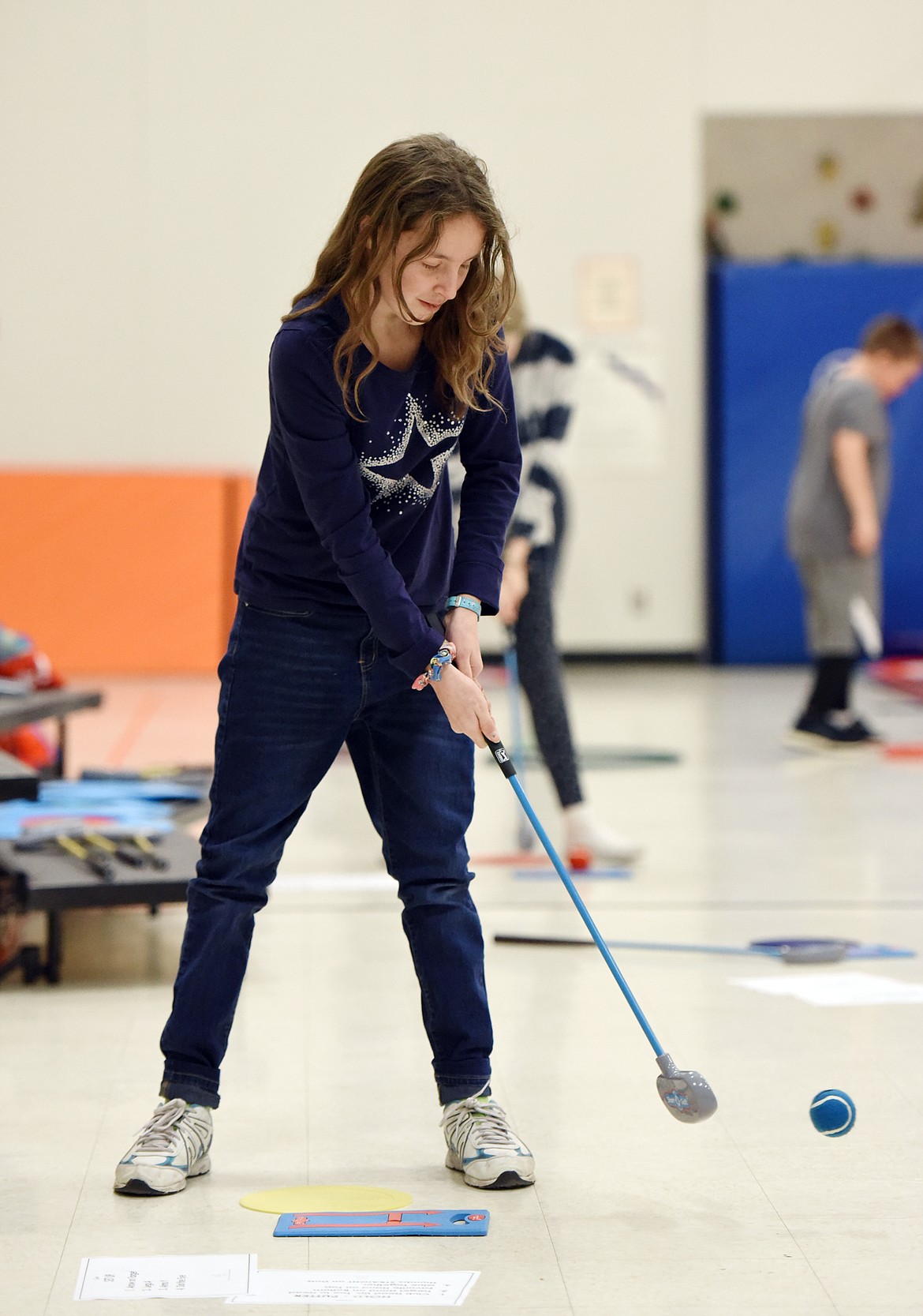 Sixth-grader Madolynn Bowman works on her putting skills during a golf program at Creston School on Wednesday, Dec. 11. (Casey Kreider/Daily Inter Lake)